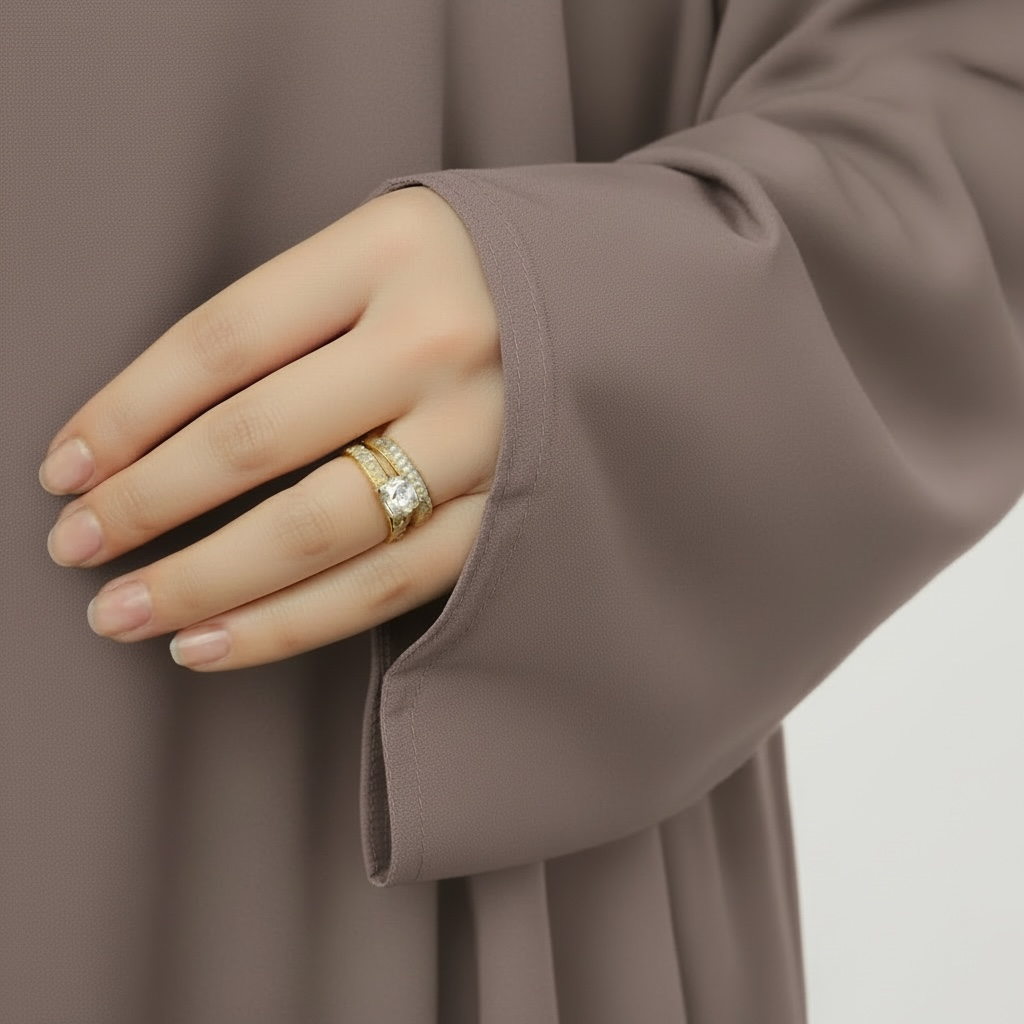 Hand wearing a gold ring with a diamond on a plain background