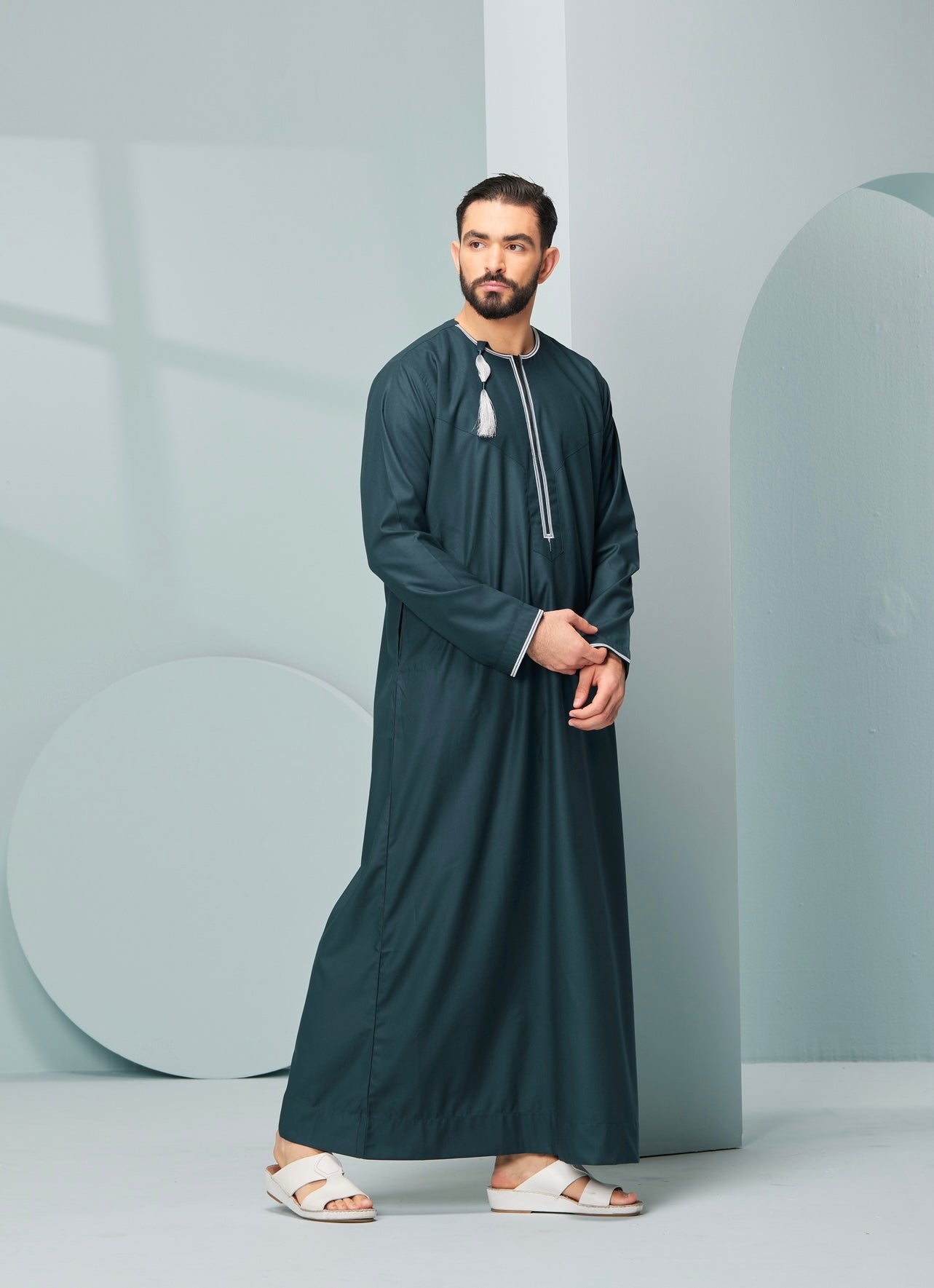 Men's Omani Style Thobe in Teal with Silver Tassel Omaar, our stylish mens embroidered Omani style thobe! thobeluxe authentic saudi thobes, premium thobes