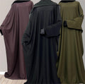Three women's traditional batwing abayas in black, brown, and green colors, displayed facing away from the camera.