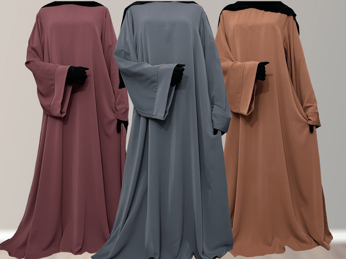 Three Nidha Abayas in different colors displayed in a row with their backs towards the camera, showcasing the wide sleeve and bell sleeve features.