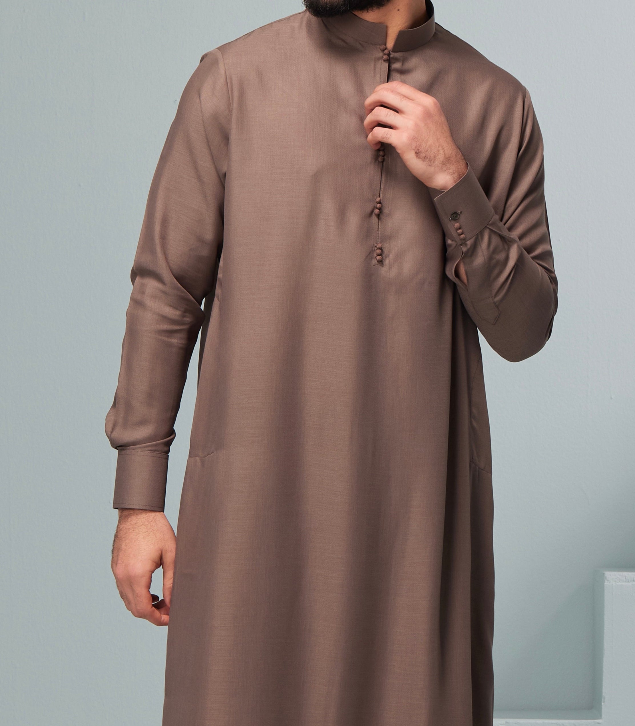 man wearing brown collard thobe