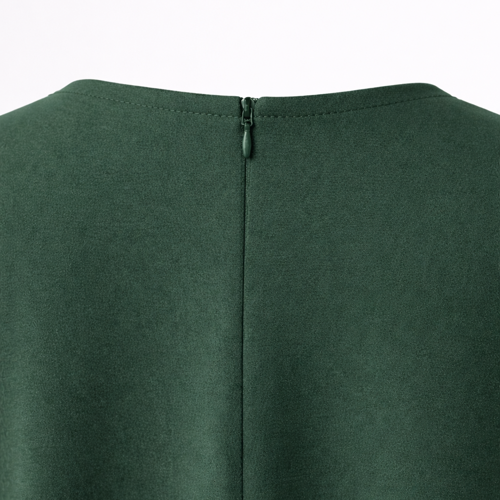 Close-up of a green garment with a zipper detail on a white background