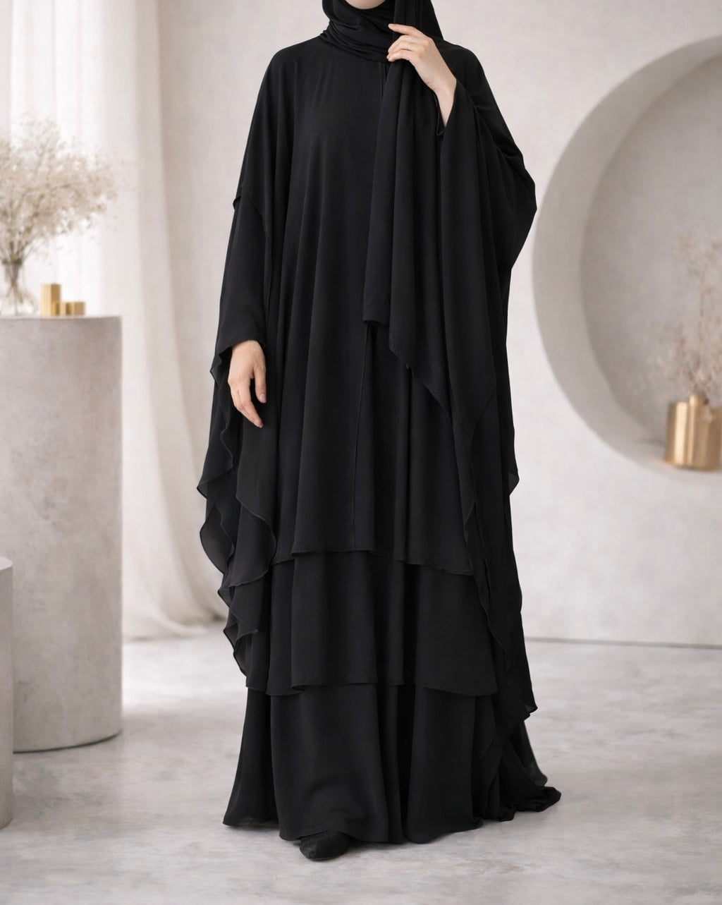 Black abaya worn by a woman in a minimalistic indoor setting